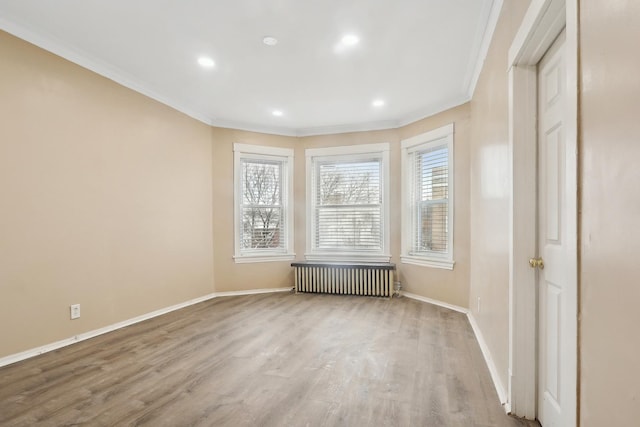 empty room featuring baseboards, crown molding, recessed lighting, radiator, and wood finished floors