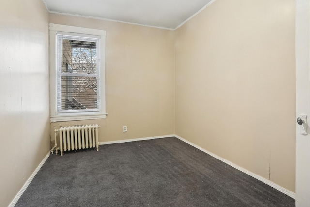 unfurnished room featuring dark colored carpet, baseboards, crown molding, and radiator