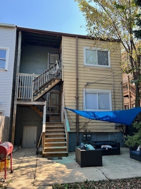 back of house featuring a patio area, stairway, and an outdoor living space