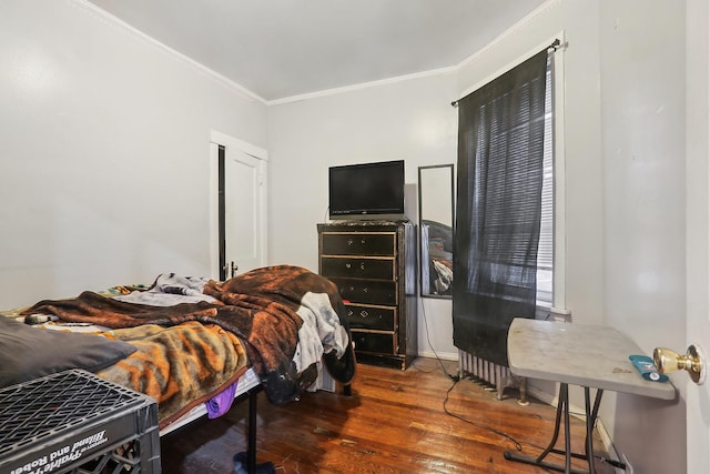 bedroom with ornamental molding and dark wood-type flooring