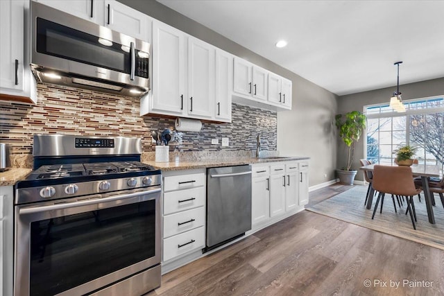 kitchen featuring sink, white cabinets, decorative backsplash, and appliances with stainless steel finishes