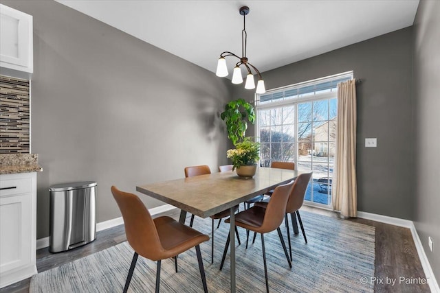 dining room with a notable chandelier and dark wood-type flooring