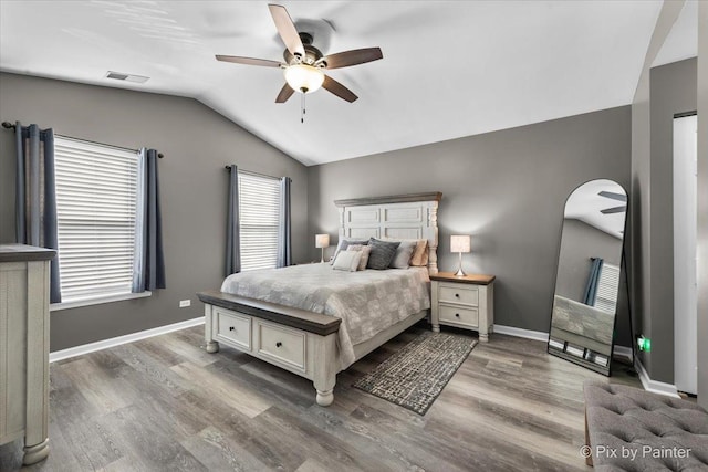 bedroom with lofted ceiling, dark wood-type flooring, ceiling fan, and multiple windows