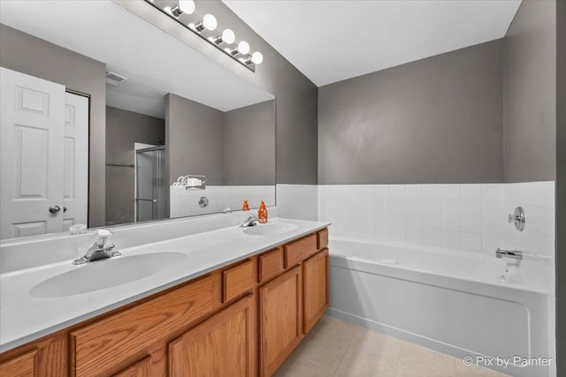 bathroom featuring tile patterned floors, vanity, and shower with separate bathtub