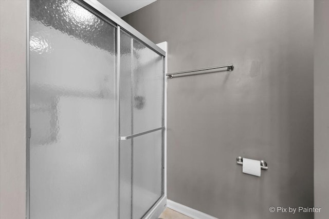 bathroom with a shower with door