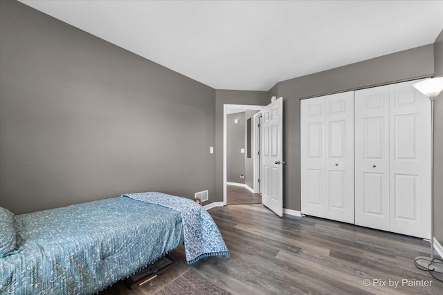 bedroom with dark wood-type flooring and a closet