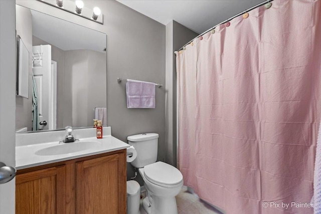 bathroom featuring a shower with shower curtain, vanity, and toilet