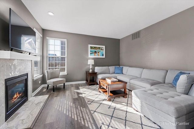 living room featuring a high end fireplace and hardwood / wood-style floors