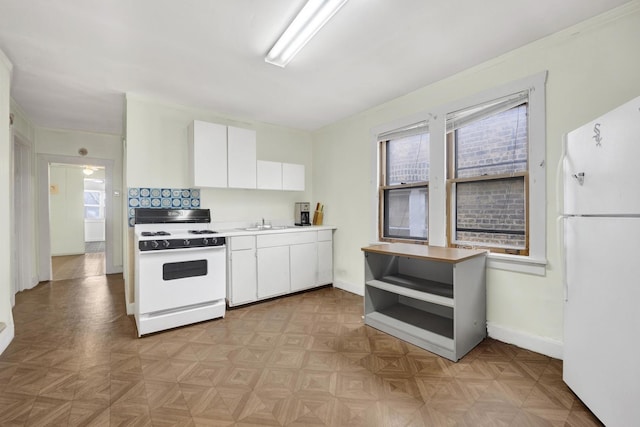 kitchen with white cabinetry, white appliances, and light parquet flooring