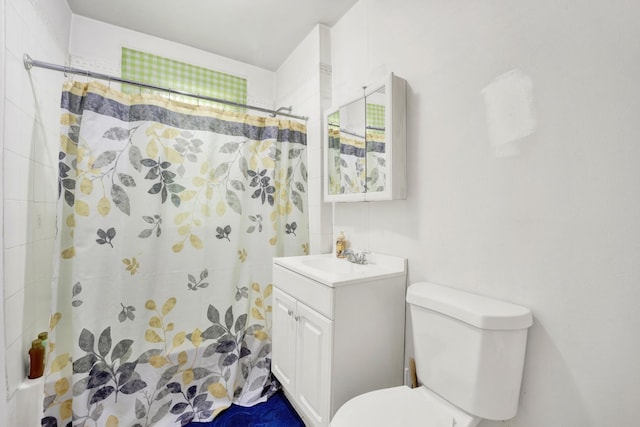 bathroom with curtained shower, vanity, and toilet