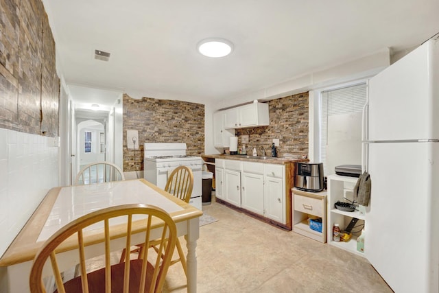 kitchen with decorative backsplash, sink, white cabinets, and white appliances