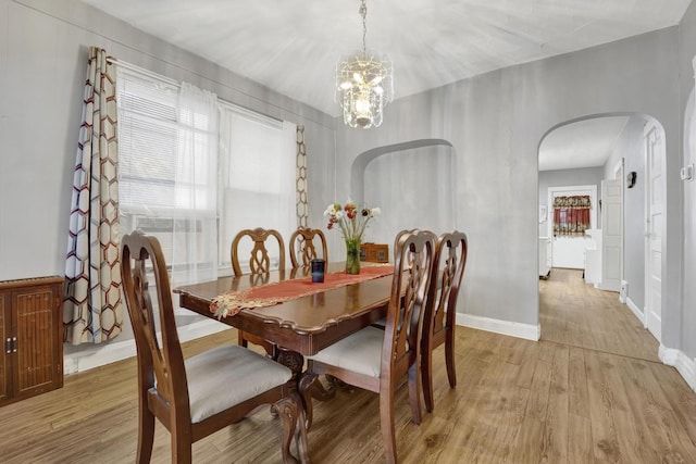 dining area featuring light hardwood / wood-style floors and a chandelier