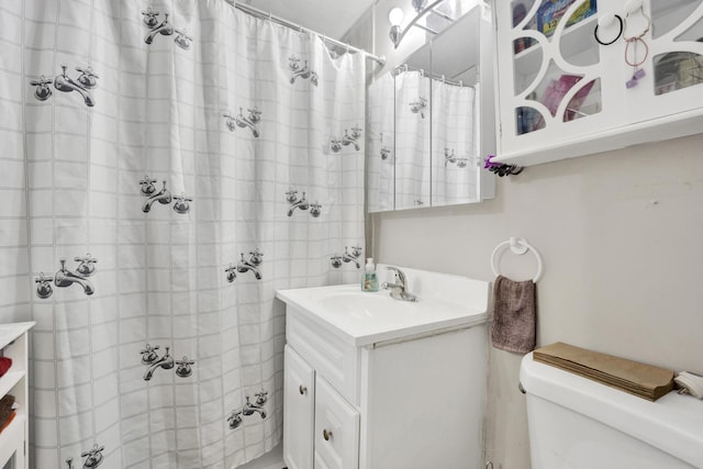 bathroom with vanity, toilet, and curtained shower