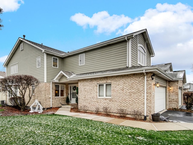 front of property with a front lawn, a garage, and central AC