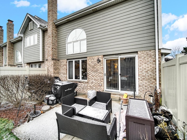 back of house with an outdoor living space and a patio area