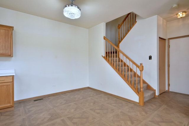 interior space with light parquet flooring and a chandelier