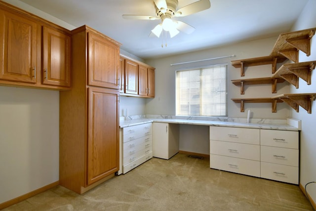 kitchen featuring ceiling fan and built in desk