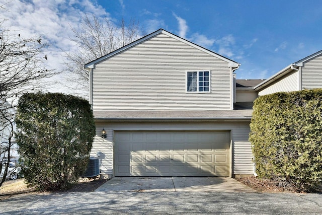 view of side of home with central AC and a garage