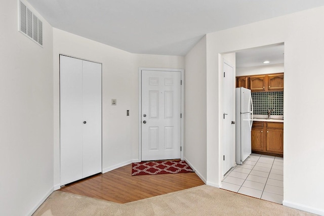 entrance foyer with sink and light carpet