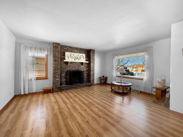 unfurnished living room featuring light wood-type flooring and a brick fireplace