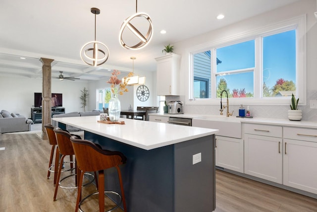 kitchen featuring sink, ceiling fan, decorative light fixtures, light hardwood / wood-style floors, and white cabinetry