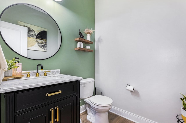 bathroom featuring vanity, hardwood / wood-style flooring, and toilet