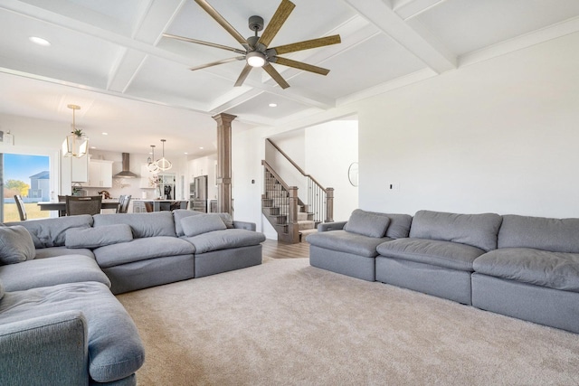 living room featuring beamed ceiling, light carpet, ceiling fan with notable chandelier, and coffered ceiling