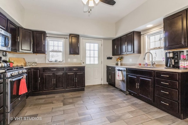 kitchen with dark brown cabinetry, sink, ceiling fan, and appliances with stainless steel finishes