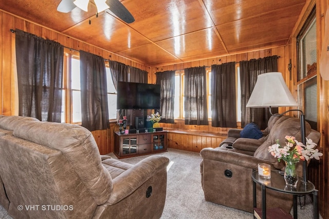 living room with ceiling fan, carpet floors, wooden ceiling, and wooden walls