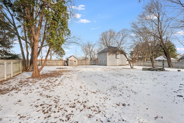 snowy yard featuring a shed