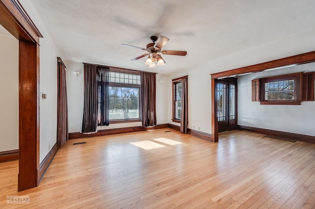 empty room with ceiling fan and light hardwood / wood-style floors