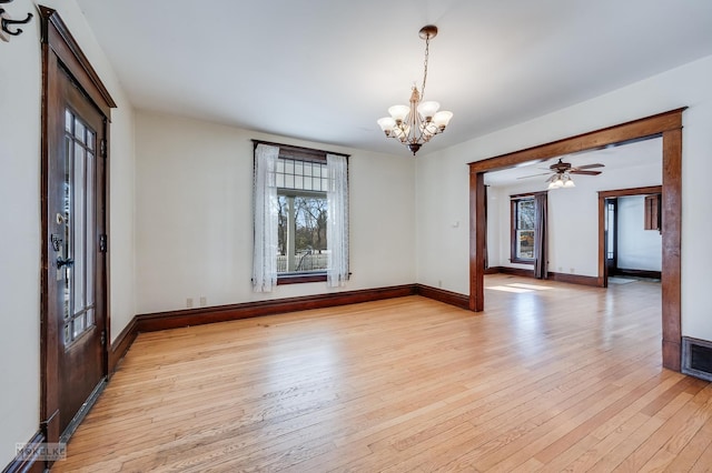 interior space with light wood-type flooring and ceiling fan with notable chandelier