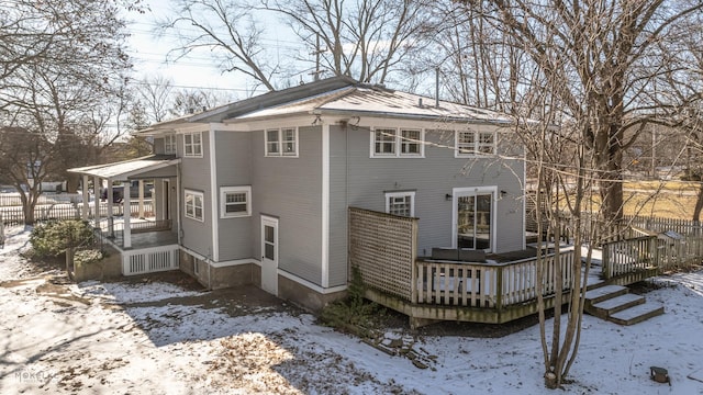 snow covered house with a wooden deck