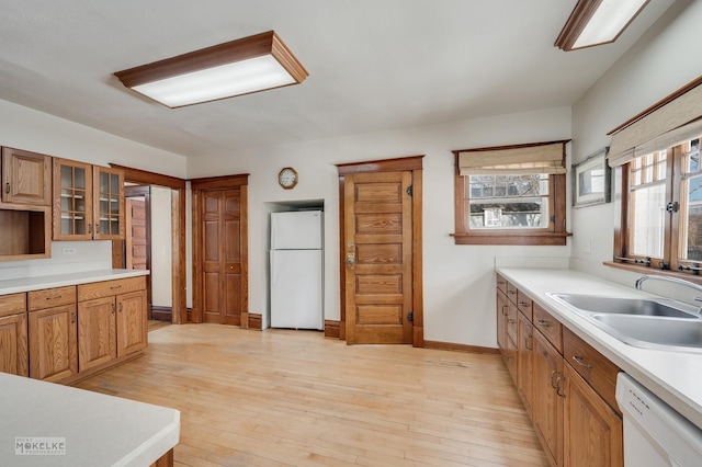 kitchen featuring sink, white appliances, and light hardwood / wood-style flooring