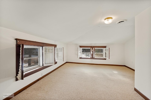 unfurnished room with vaulted ceiling and carpet floors