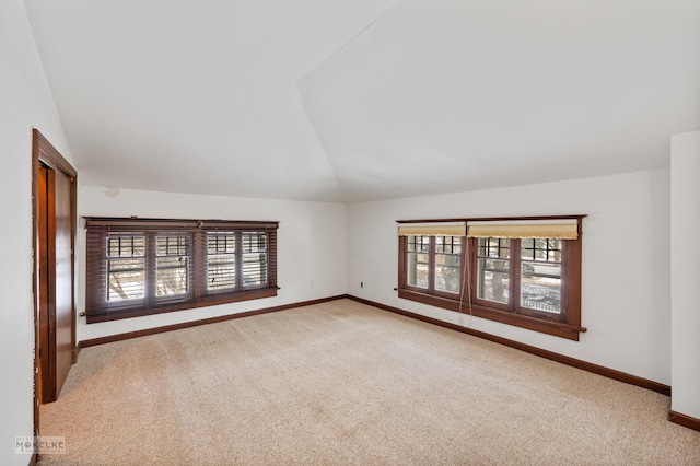 unfurnished room with vaulted ceiling and carpet flooring