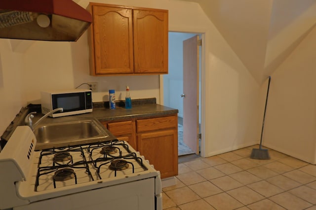 kitchen featuring sink, light tile patterned flooring, white range with gas stovetop, and vaulted ceiling