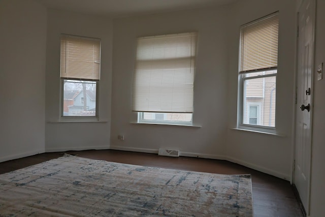 empty room with dark hardwood / wood-style flooring