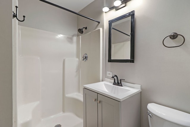 bathroom featuring walk in shower, vanity, and toilet