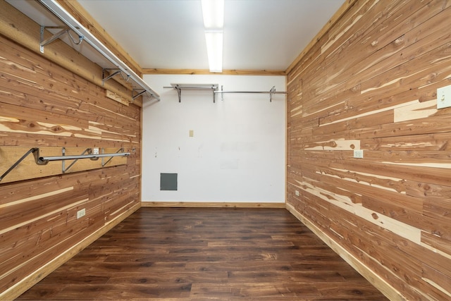 basement featuring wood walls, crown molding, and dark wood-type flooring