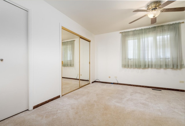 unfurnished bedroom with ceiling fan and light colored carpet