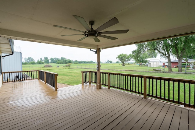 wooden terrace with a lawn, ceiling fan, and a rural view