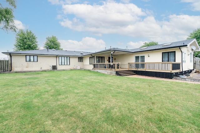 back of property featuring central AC, a deck, and a lawn