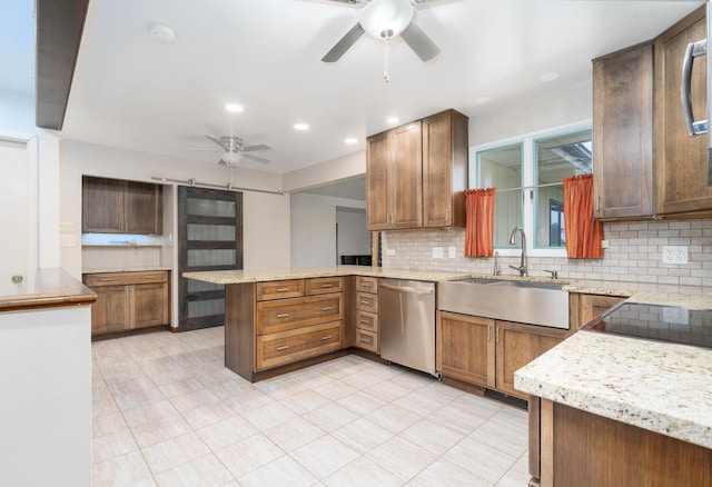 kitchen featuring kitchen peninsula, decorative backsplash, sink, and stainless steel dishwasher