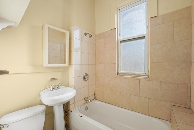 bathroom featuring tiled shower / bath and toilet