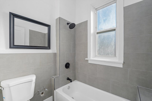 bathroom featuring toilet and tiled shower / bath combo