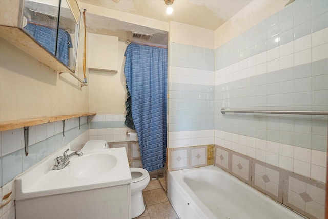 bathroom with tile walls, toilet, tile patterned floors, and vanity