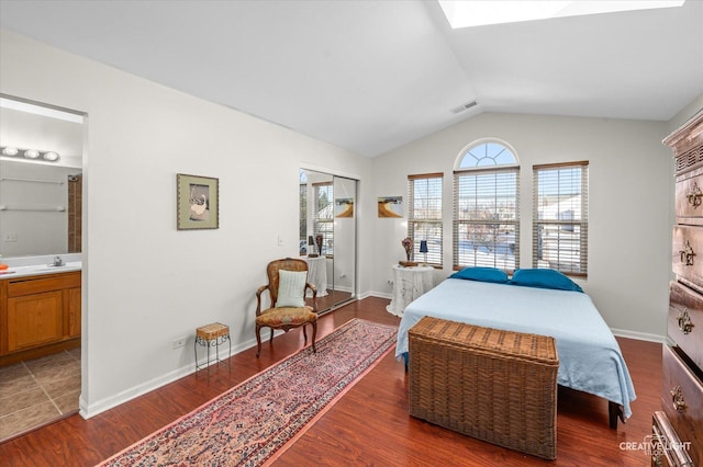 bedroom with ensuite bath, sink, dark wood-type flooring, and lofted ceiling