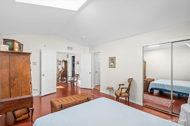 bedroom featuring hardwood / wood-style floors, vaulted ceiling with skylight, and a closet