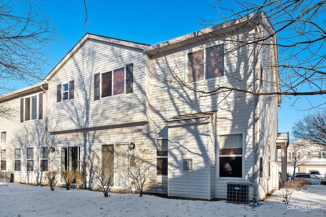 snow covered house featuring central AC